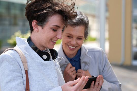 Reading, friends and business people with phone in city, watch video and social media post for smile, Connection, bonding and happy women with tech for internet meme, blog story or share news in town