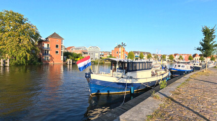 Obraz premium Moored Canal Boat with Dutch Flag on Haarlem Waterfront