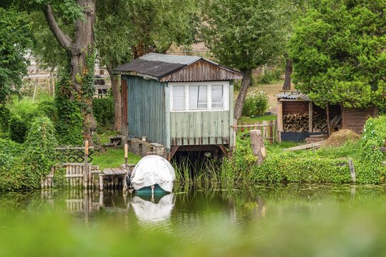 Old wooden boathouse, Templin canal, St. Mary Magdalene Church in the back, Templin, Uckermark, Brandenburg, Germany