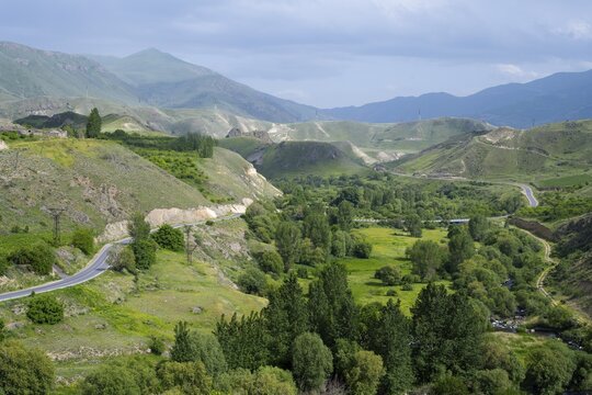 Landscape with green valleys and winding roads surrounded by trees and mountains, view from Vorotnavank Monastery, Vorotnavank, situated in the Vorotan Valley, Vorotan, Syunik Province, Armenia