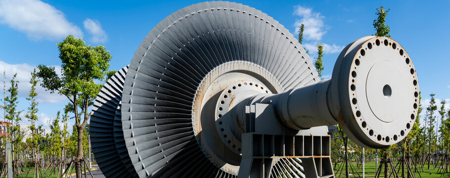 The core rotating components of the steam turbine under the blue sky and white clouds outdoors