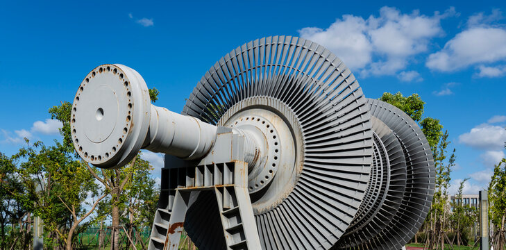 The core rotating components of the steam turbine under the blue sky and white clouds outdoors