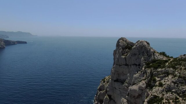 passage &agrave; basse altitude sur la cr&ecirc;te de la calanque de Sormiou au sud de Marseille, en &eacute;t&eacute;, avec des bateaux dans la baie