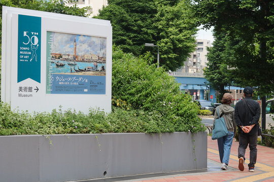 TOKYO, JAPAN - May 20, 2026: Street in Shinjuku with a sign for a Sompo Museum of Art with poster for Eugene Boudin exhibition.