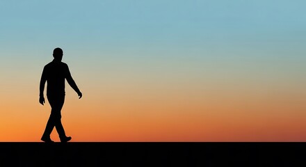 Fototapeta premium Man walking alone at sunset horizon.