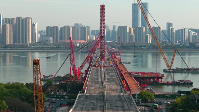 Aerial view of a large bridge over the river is in the process of being dismantled using cranes.