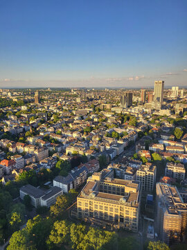 View from an elevated vantage point across the densely built rooftops of a Frankfurt inner-city neighbourhood toward the skyline of the financial district. 