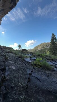 Unveiling a breathtaking mountain landscape from under a cavern ceiling.