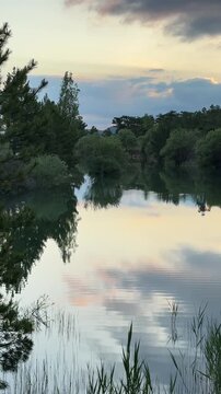 Scenic beauty of a mountain lake reflecting green trees and low clouds