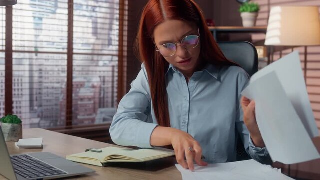 Serious multitasking Caucasian business woman writing notes working with laptop and paperwork in corporate office businesswoman girl female work busy with computer check diagram documents multitask