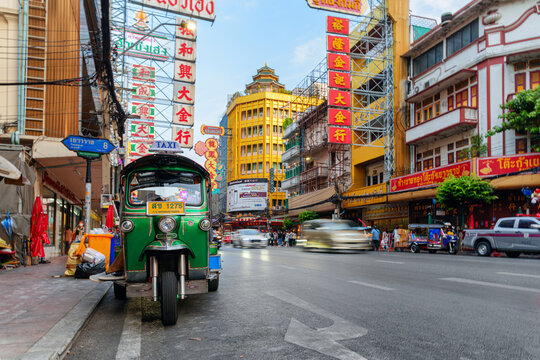 Green tuk-tuk parked on Yaowarat Road at Chinatown of Bangkok