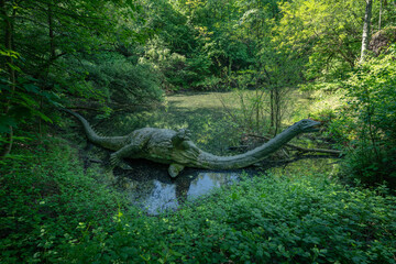Drowning herbivorous dinosaur figurine in a lake. © lapis2380