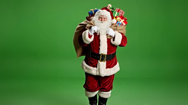 Santa Claus carrying a large sack of gifts on a green screen background.