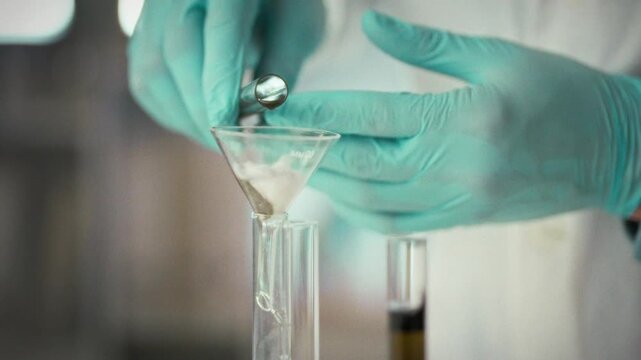In laboratory, scientist filters liquid during an experiment, employing precise equipment and specialized tools. The meticulous process ensures accurate results and highlights scientific methodology