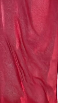 Close-up of draped red heavy-duty industrial tarpaulin fabric.