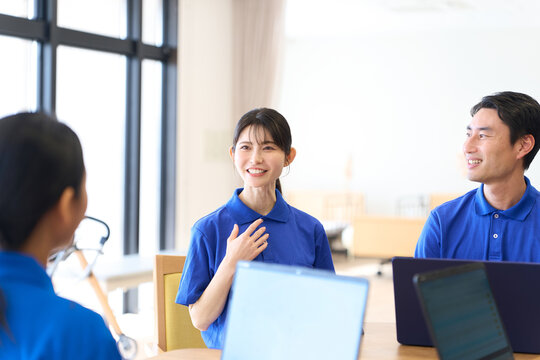 介護施設でミーティングをするアジア人介護士
