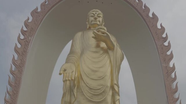 4K resolution tilt up cinematic shot of the giant golden Amitabha Buddha bronze statue with flame shaped halo at Donglin Temple in Jiujiang, shot in ProRes Log format.