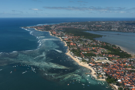Aerial view of Bali&rsquo;s developed south coast with beaches, reef flats, hotels, boats, urban areas and the mangrove-lined bay near Denpasar, Indonesia.