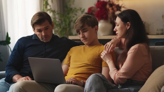 Teen boy and his parents browsing colleges on a laptop at home, future planning