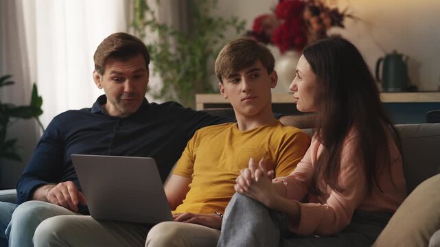 Teen boy and his parents choosing online educational courses together at home