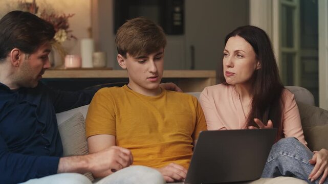 Parents giving advice to teen son while choosing universities online together