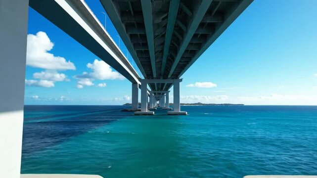 Low Angle Perspective of a Concrete Bridge Spanning Over Turquoise Water on a Sunny Day