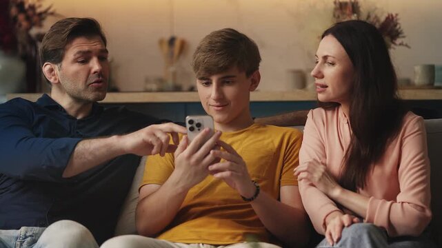 Parents and their teen son using a smart home app on smartphone together