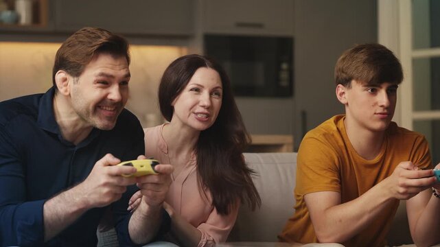 Woman cheering for her son and husband competing in a video game together