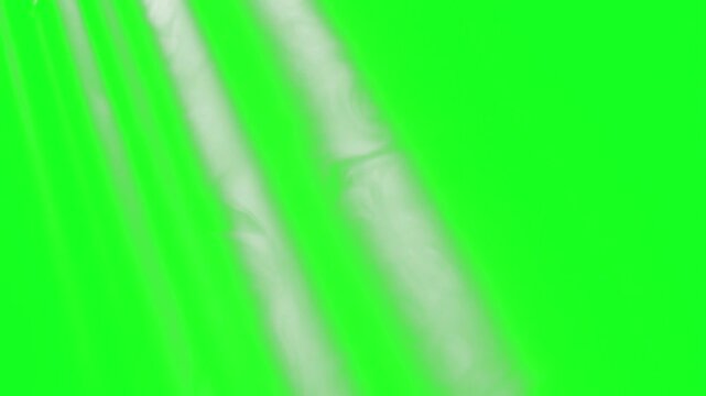 Strong diagonal parallel rays and sun shafts project across a green screen chroma key background. This high-quality visual effect asset is designed for premium cinematic video