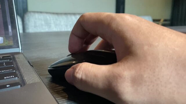Person using wireless computer mouse on desk