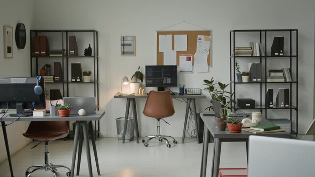 No people wide establishing shot of software development company office, with several programmers desks, computers, laptops, racks with business documents and pin board with project plans