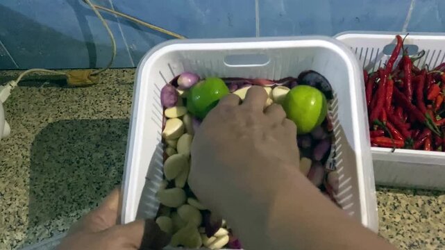 POV shot of crushing fresh red chilies to make homemade chillie paste. Footage clip capturing the authentic process of making homemade Indonesian sambal chili paste.