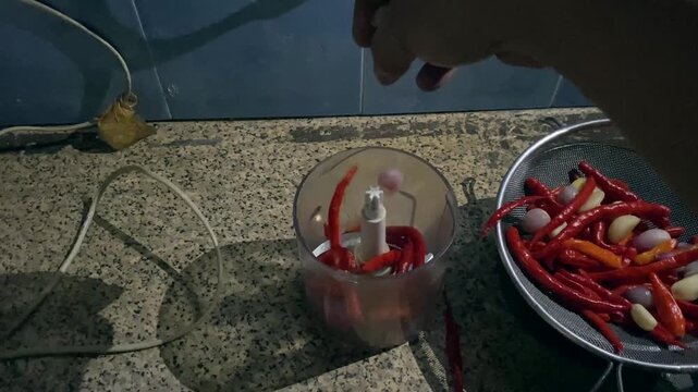 POV shot of crushing fresh red chilies to make homemade chillie paste. Footage clip capturing the authentic process of making homemade Indonesian sambal chili paste.