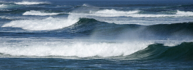Powerful waves crash with white foam against deep blue ocean © WendlerCanning Photo