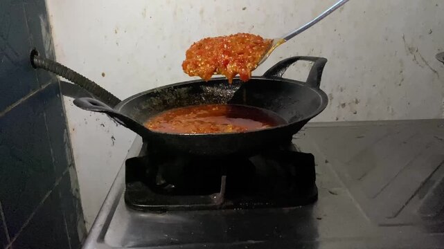 POV shot of crushing fresh red chilies to make homemade chillie paste. Footage clip capturing the authentic process of making homemade Indonesian sambal chili paste.