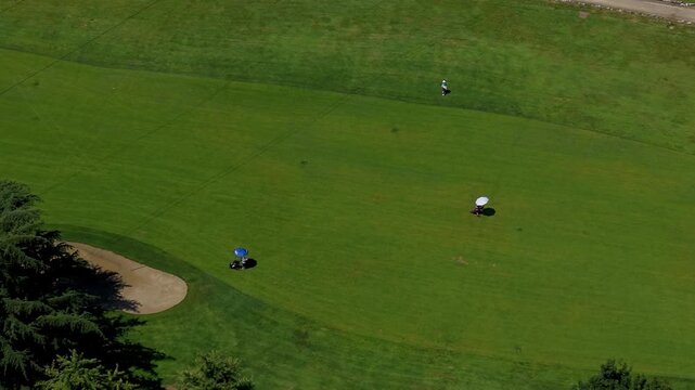Golf Course Landscape: An aerial view of a pristine golf course with lush green fairways, a sand trap, and a golf cart, showcasing a tranquil setting for a game.