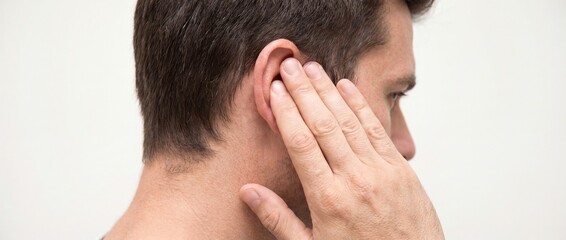 Fototapeta premium Man touching his ear with his hand on a white background with a concerned expression