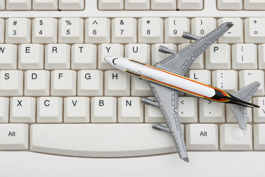 Airplane on a white computer keyboard for booking a flight online