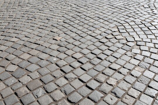 A cobblestone street with a circular pattern in the middle