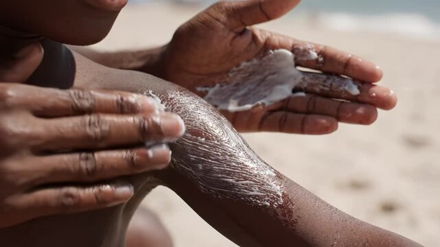Person applying sunscreen on beach