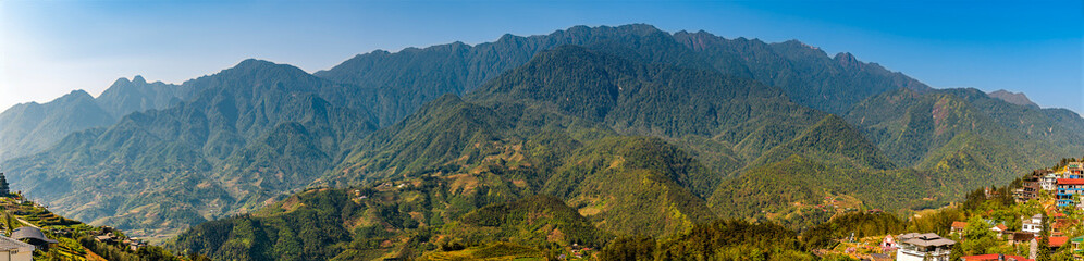 Fototapeta premium A panorama view across into the Muong Hoa Valley towards the Hoang Lien Son mountains from Sapa, Vietnam, in the morning