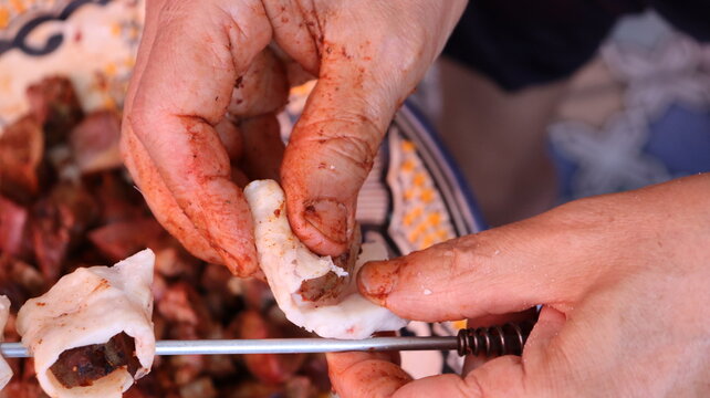 Threading boulfaf liver wrapped in caul fat on Moroccan skewer