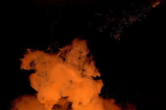 Orange colorful fluorescent smoke on black background,Art abstract smoke texture,Colored liquid dye,Splash paint,Abstract color,Abstract Textures