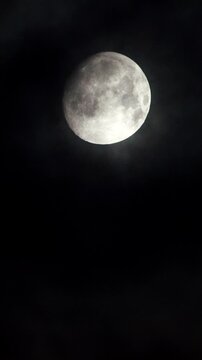 Full moon at night on black sky, moonlight. Vertical video