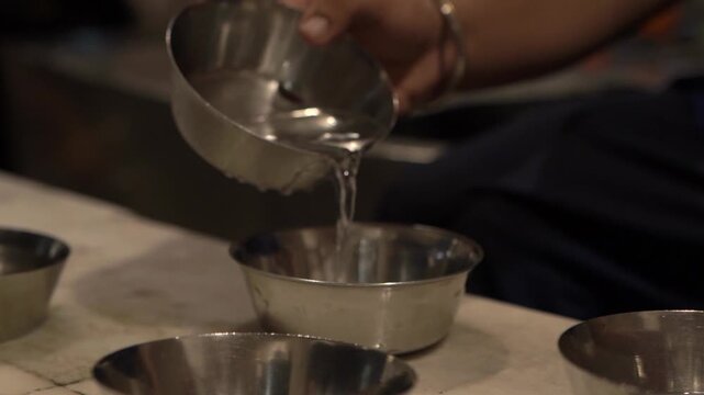 Hands cleaning kitchen utensils as part of community seva at Sri Harmandir Sahib.