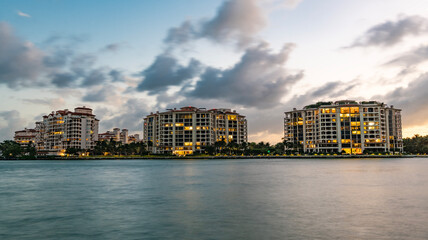Obraz premium Fisher island cityscape. Luxury building of Fisher island, Miami. Miami beach cityscape. Miami on sunset, Florida. Sunset view of Fisher island. Luxury condominiums