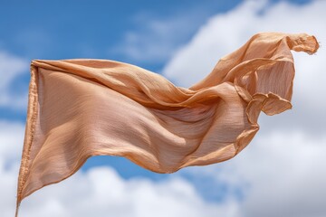 Light peach fabric banner flowing in the wind against blue sky with clouds