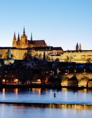 Fototapeta premium Stunning night view of Prague Castle illuminating the Vltava River in Czechia