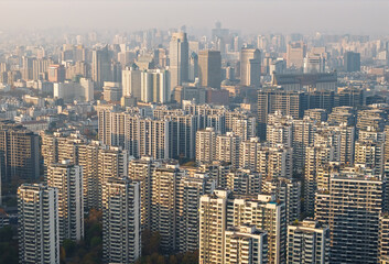 Fototapeta premium Massive modern high-rise buildings dominate an expansive urban cityscape during an autumn day