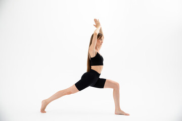 Fototapeta premium Beautiful brunette fitness woman doing yoga on a white background